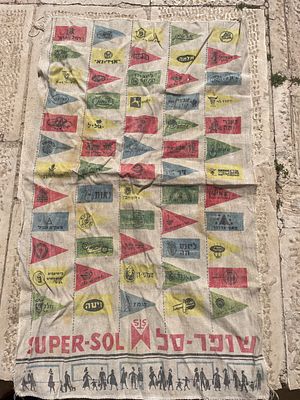בד פרסומי מתקופת "ישראל הישנה" (ככל הנראה שנות ה-60 או ה-70). הפריט מרכז בתוכו עשרות סמלים 