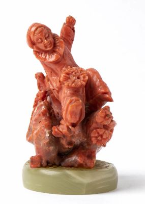 A Mediterranean (Corallium Rubrum)carving depicting "pulcinella" placed on a stone base. 