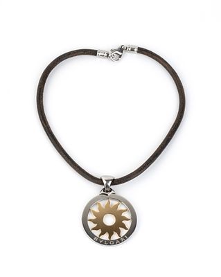 BULGARI - the pendant depicting a sun in 18k yellow gold inscribed in a steel circle is suspended 