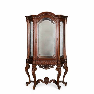 VITRINE. Vitrine em madeira de nogueira com entalhamentos, cimalha curva, frente e lados 