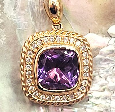 Brazilian Amethyst and Diamond Halo Pendant. This is a 14 karat yellow gold pendant that 