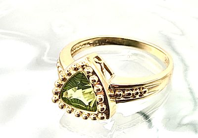 Fancy Trilliant-Cut Peridot Ring. Setting: 14K Yellow Gold
Main Gemstone: Genuine