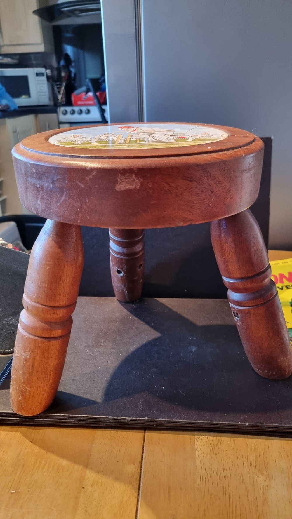 Three legged stool with 
Cricket tile top has cracked 
And legs loose