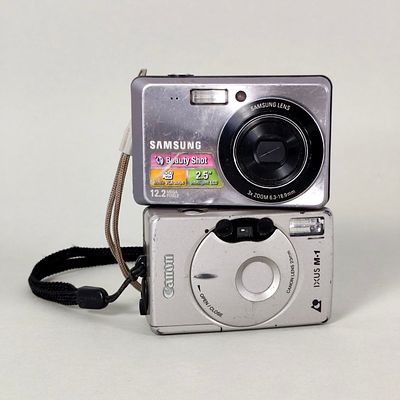 LOT OF 2 VINTAGE CAMERAS: CANON IXUS M-1 (ANALOGUE) & SAMSUNG ESGO (DIGITAL). This lot includes 
