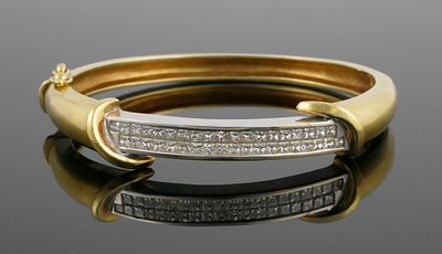 18K Gold Diamond Bracelet. 18 karat yellow and white gold hinged bangle bracelet set with two