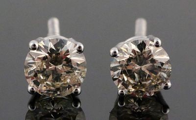 14k White Gold One Carat Diamond Earrings. Pair of white gold earrings, each set with a 