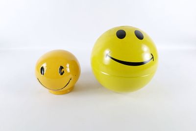 Lot of 2 Smiley Face Banks. Including Metal and Ceramic. The ceramic bank has some paint loss. 