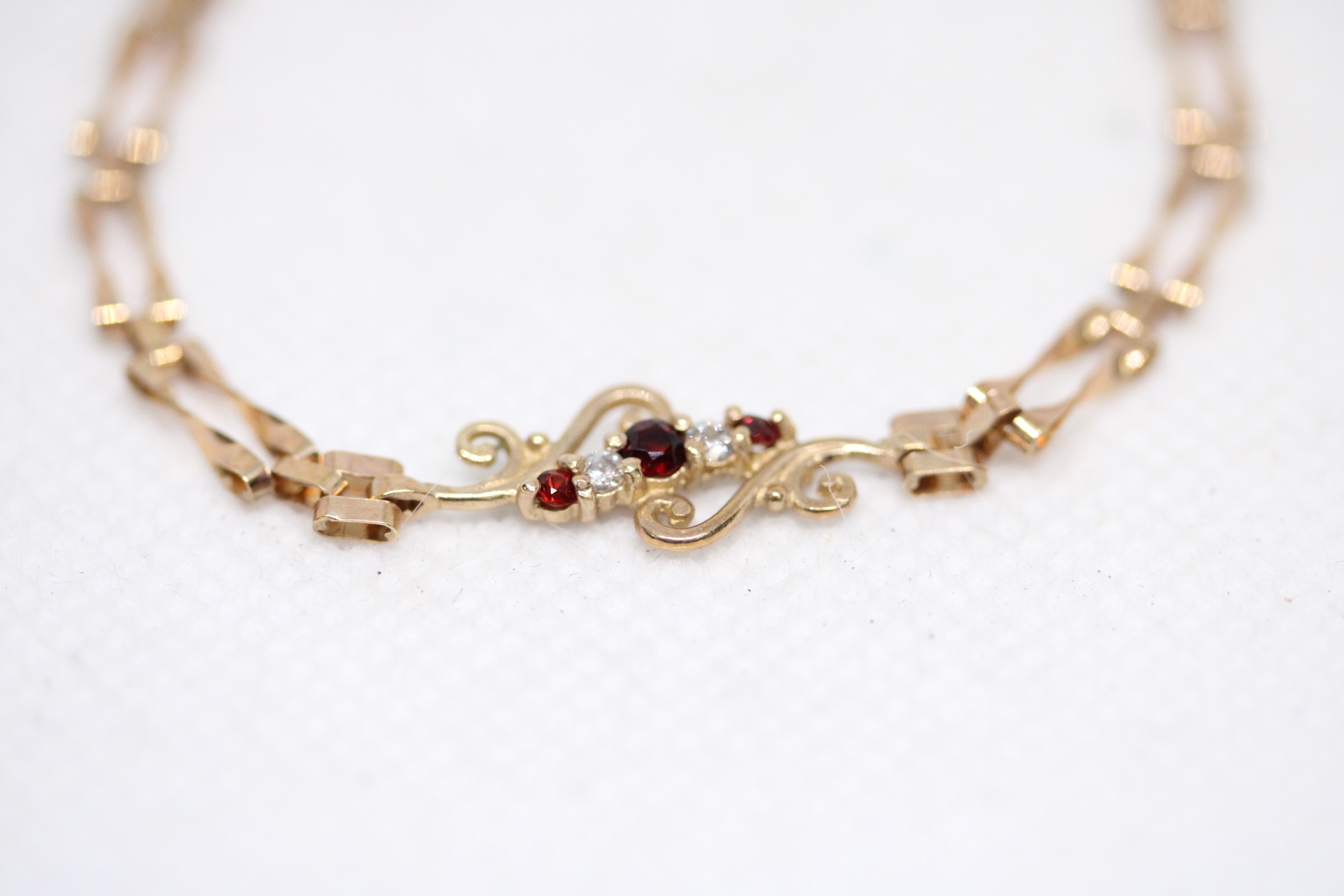 9ct Gold bracelet set with 3 garnets & 2 white stones Weight 2.8g