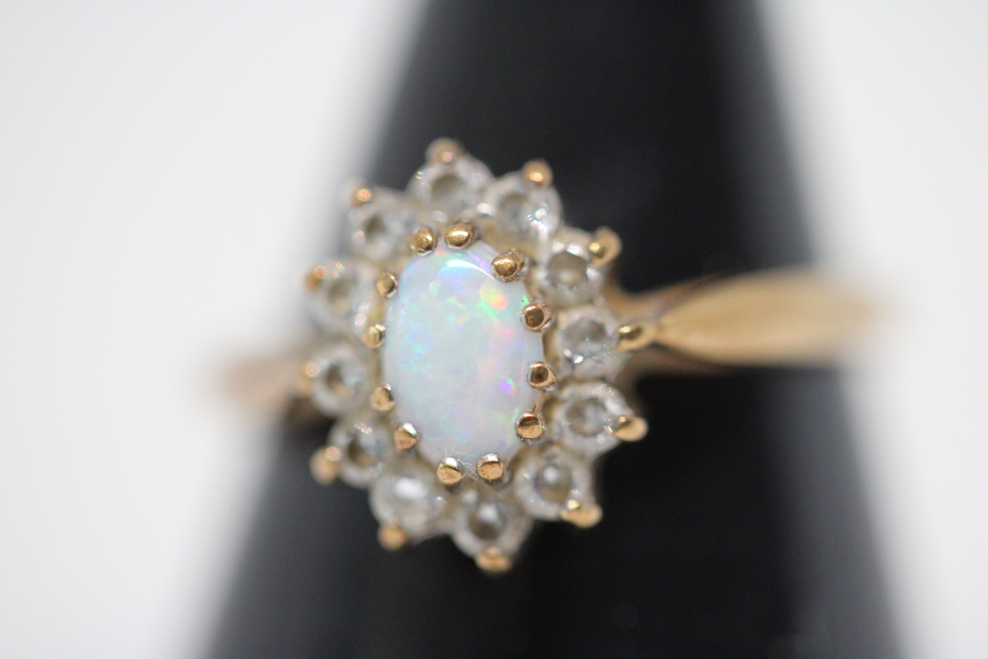 9ct Gold ring set with central opal surrounded by diamond Size M Weight 1.7g