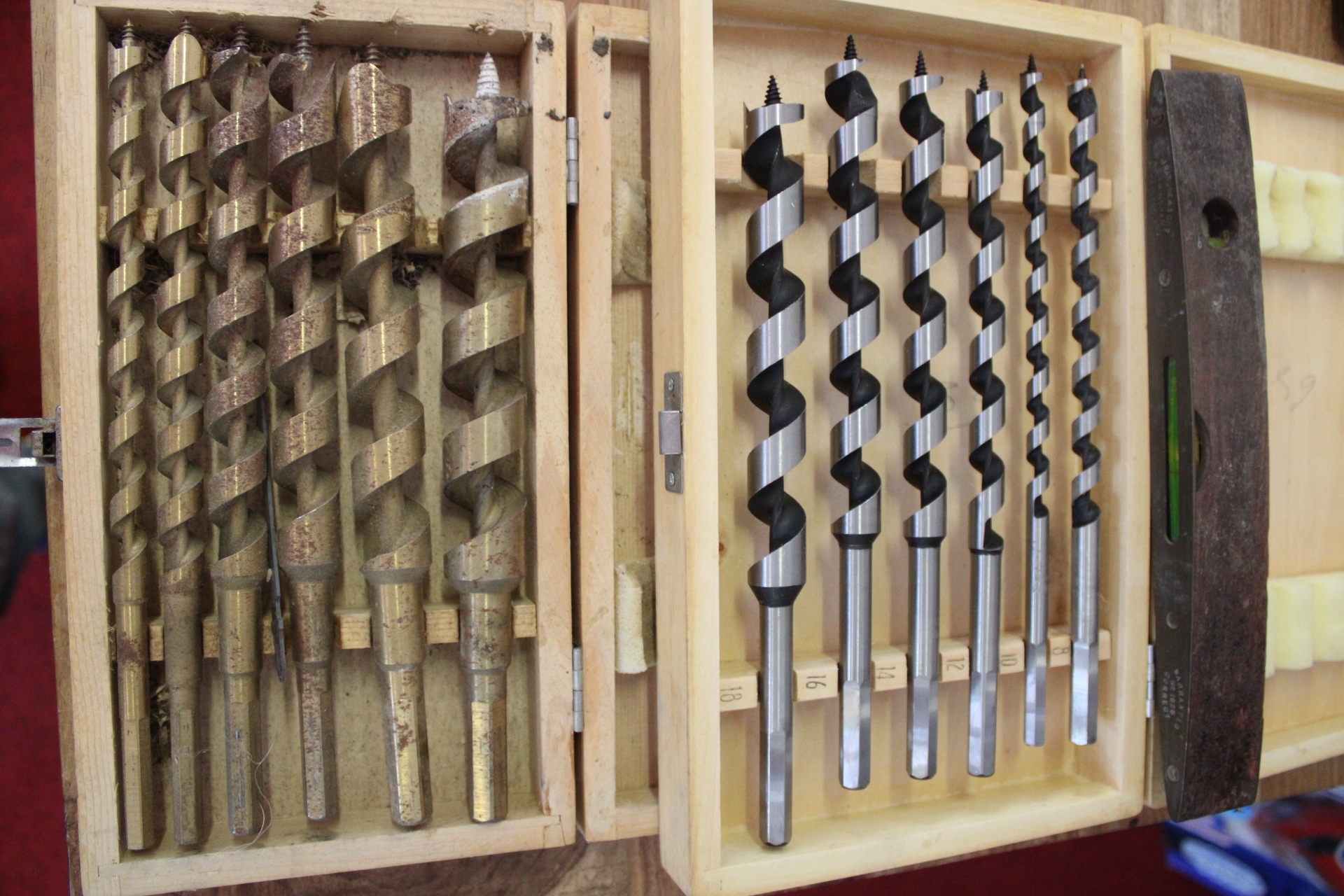 An Assortment of Vintage Woodworking Tools Including Auger Bit Sets and a Carpenter's Level