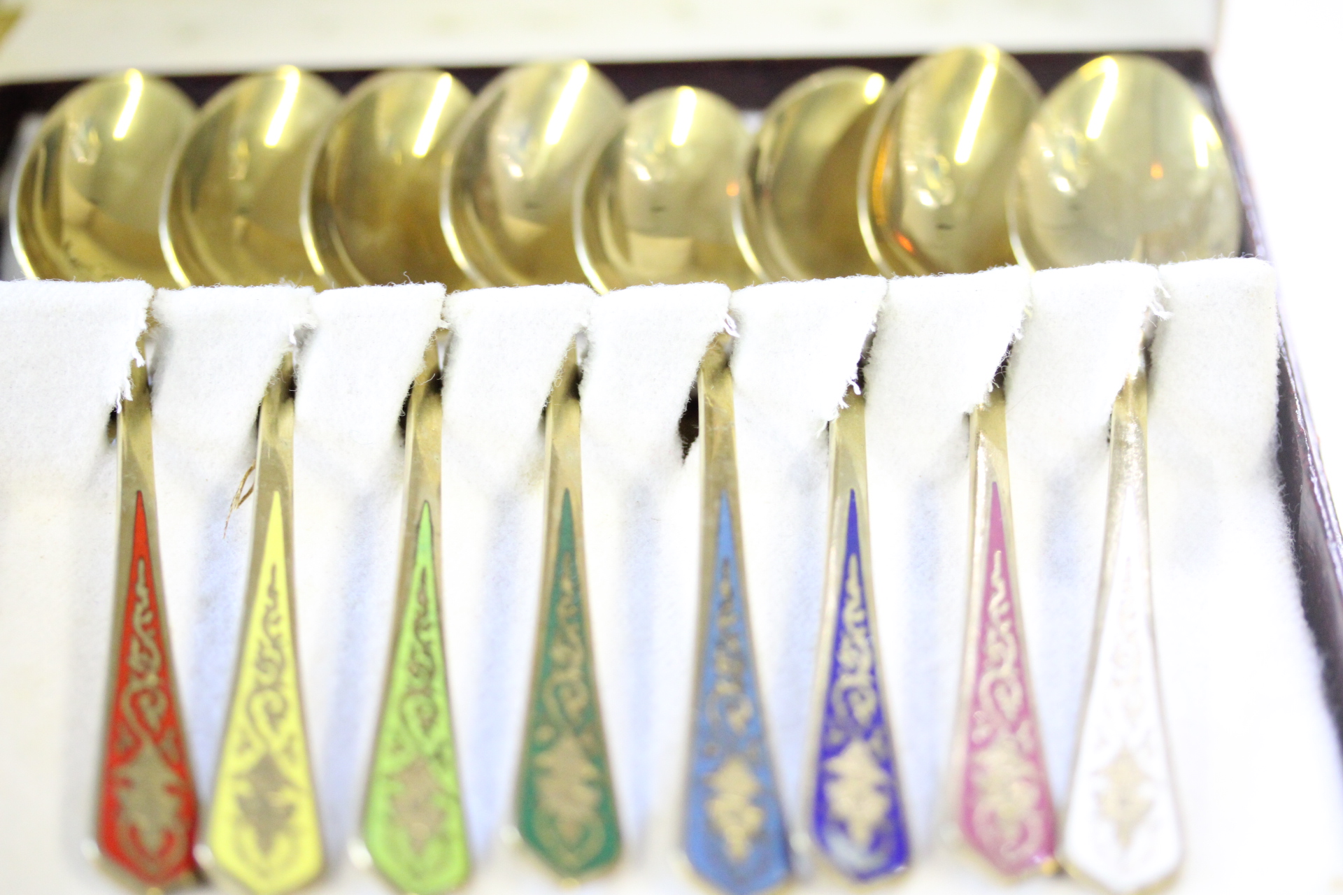 Cased set of gold plated & enamel spoons
