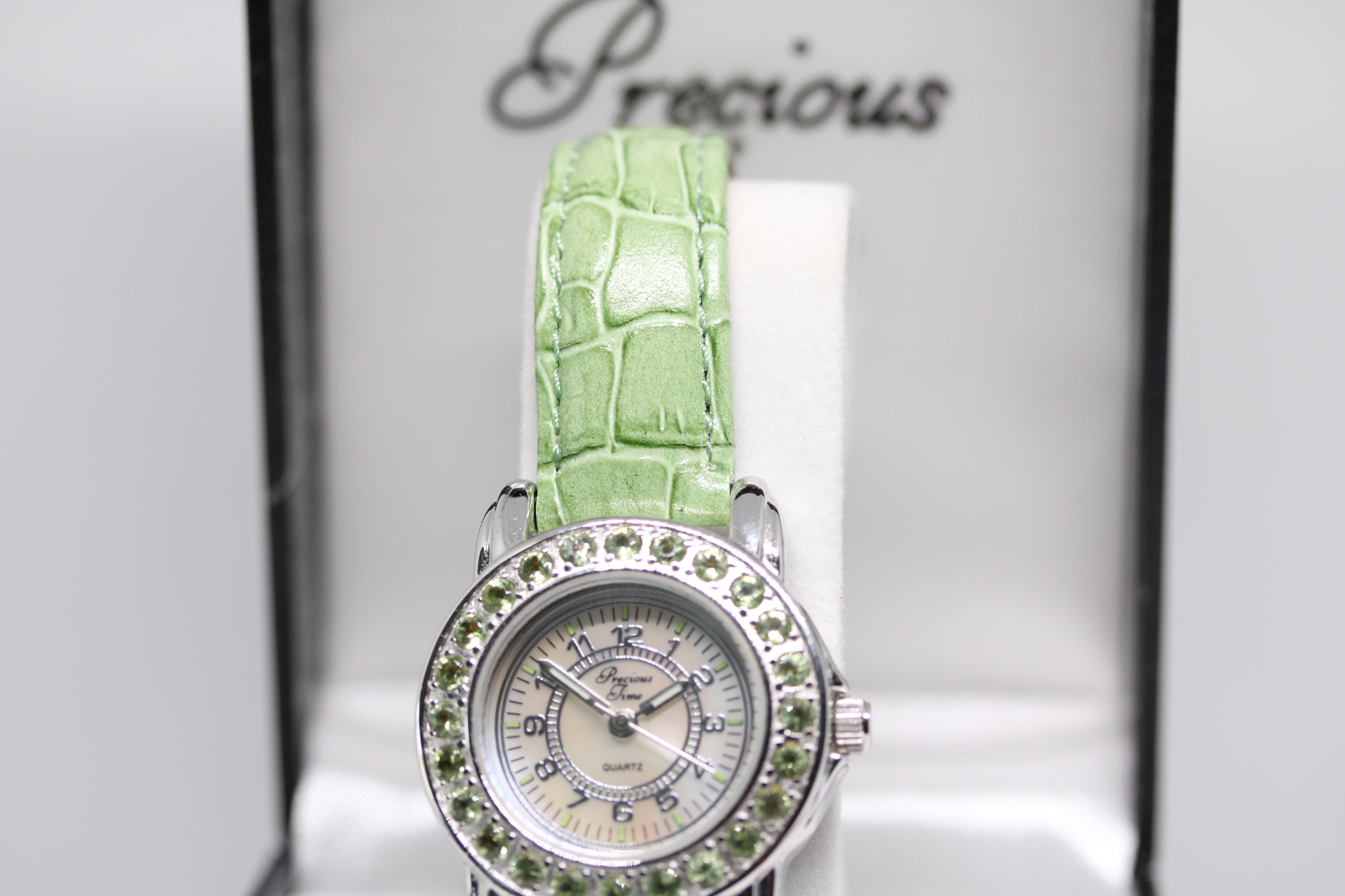 Precious Time Ladies Watch with Mother Of Pearl Dial and Green Gemmed Bezel.
