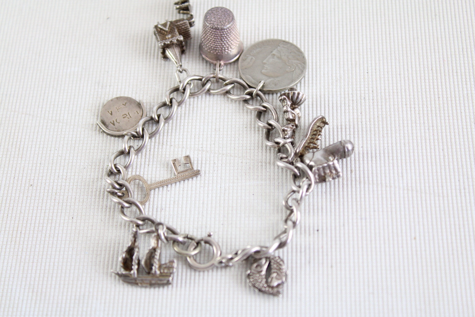 Silver charm bracelet - 9 charms 37g