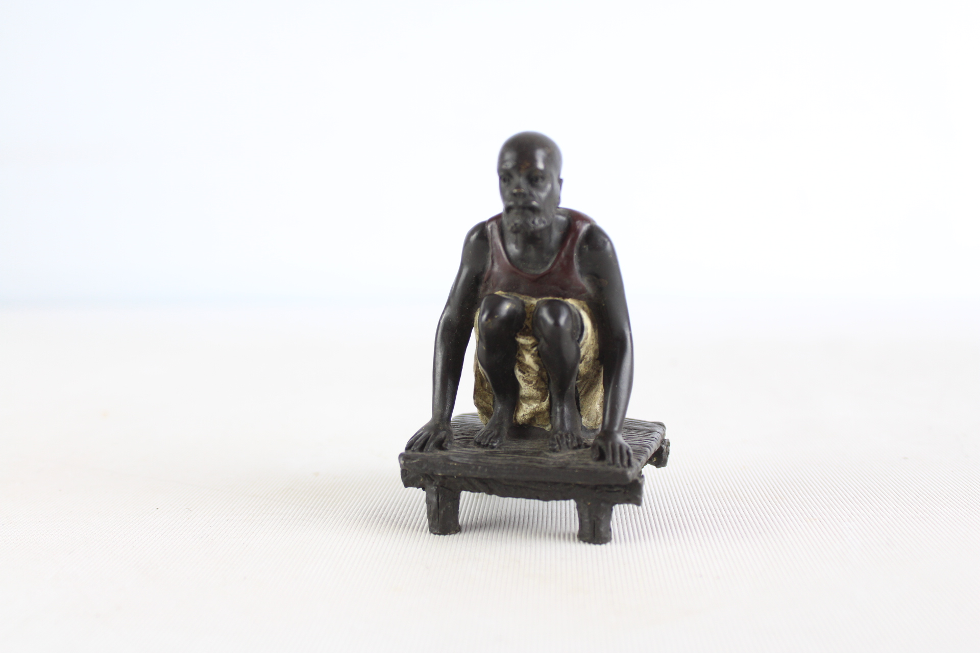 Cold painted bronze figure sqautting