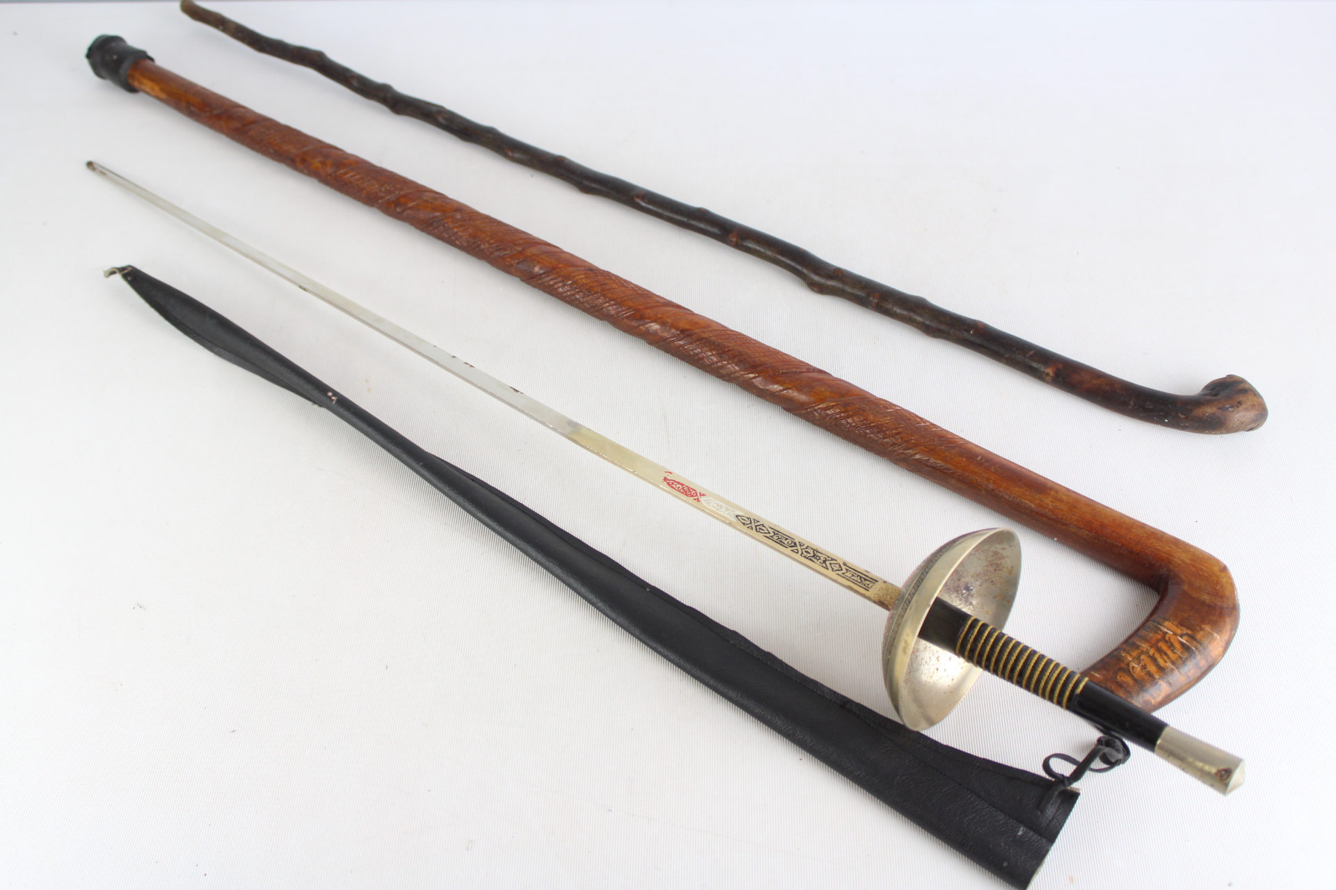 A Collection of Four Items Including a Fencing Foil and Walking Sticks