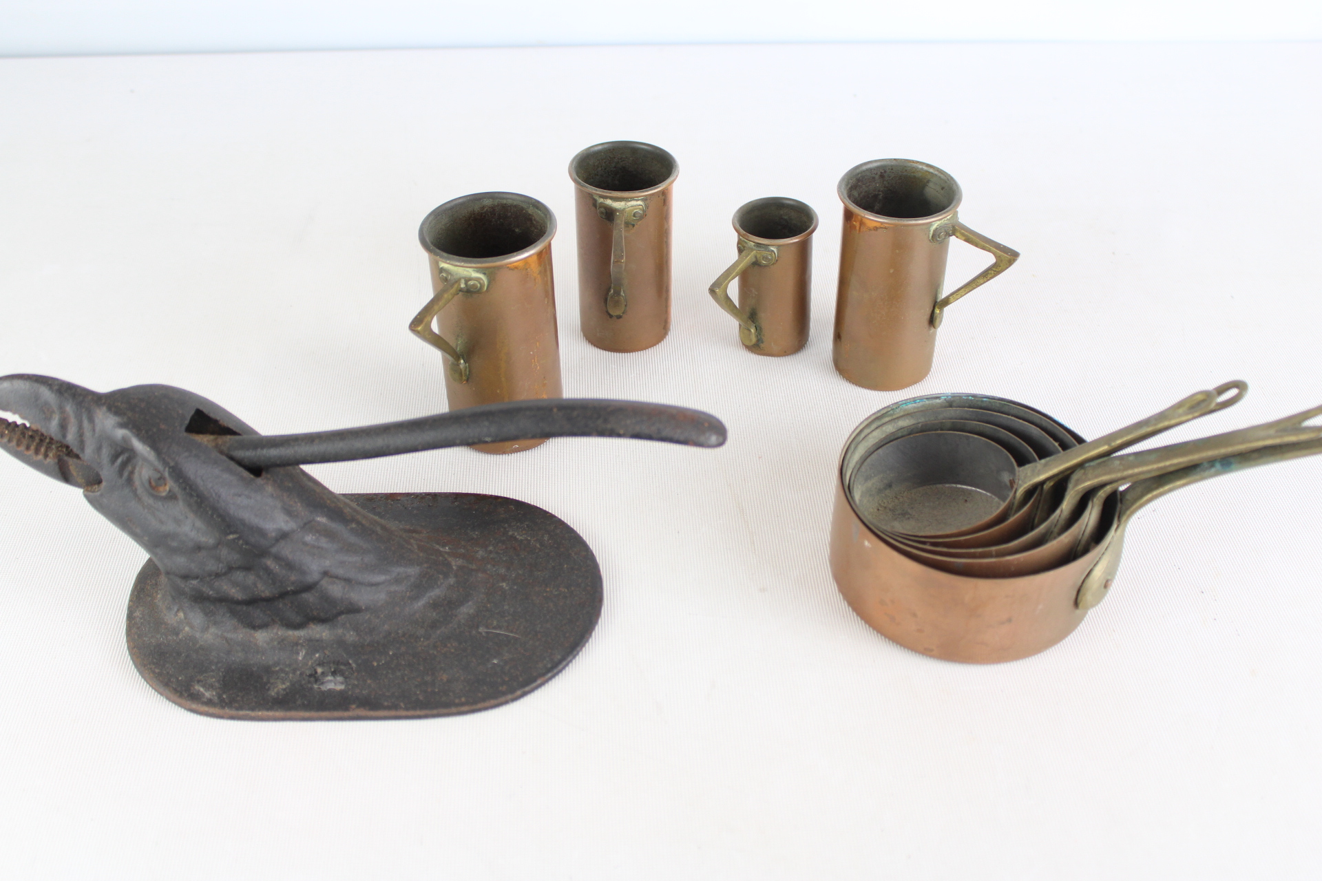 A Collection of Vintage Metalware Including a Figural Cast Iron Nutcracker and Copper Measures