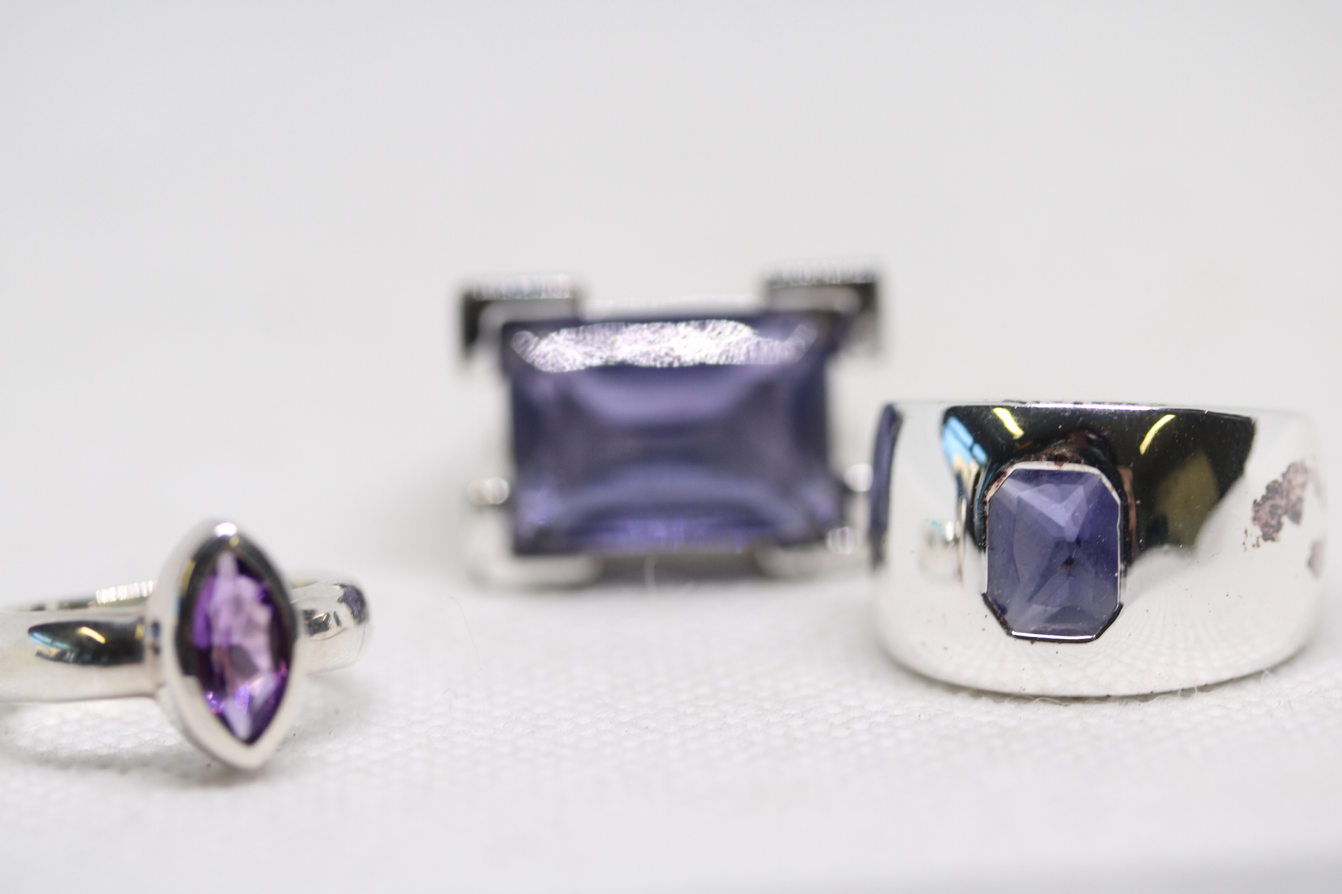 3 Silver rings set with purple stones