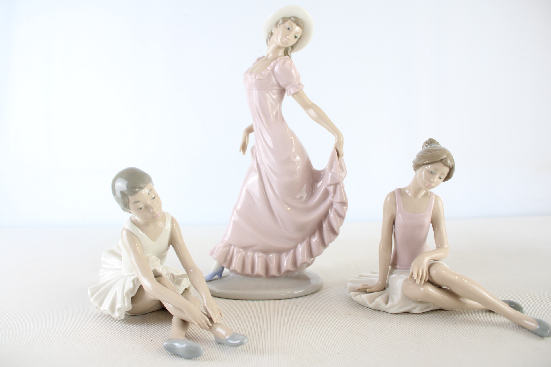 A Trio of NAO by Lladro Glazed Porcelain Figurines