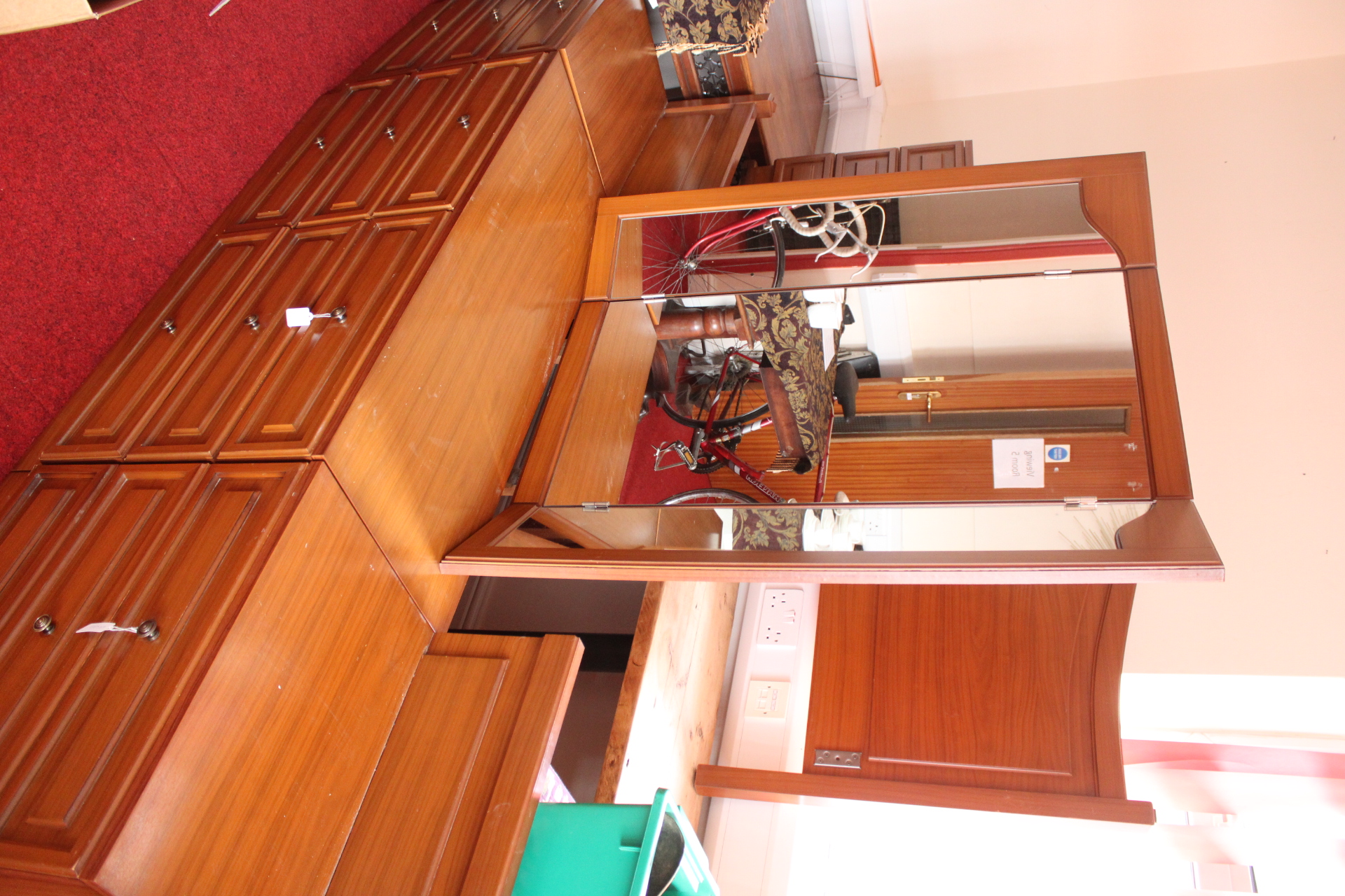 A Multi-Piece Bedroom Furniture Suite Comprising a Dresser with Mirror, Headboard, and Bedside Chests