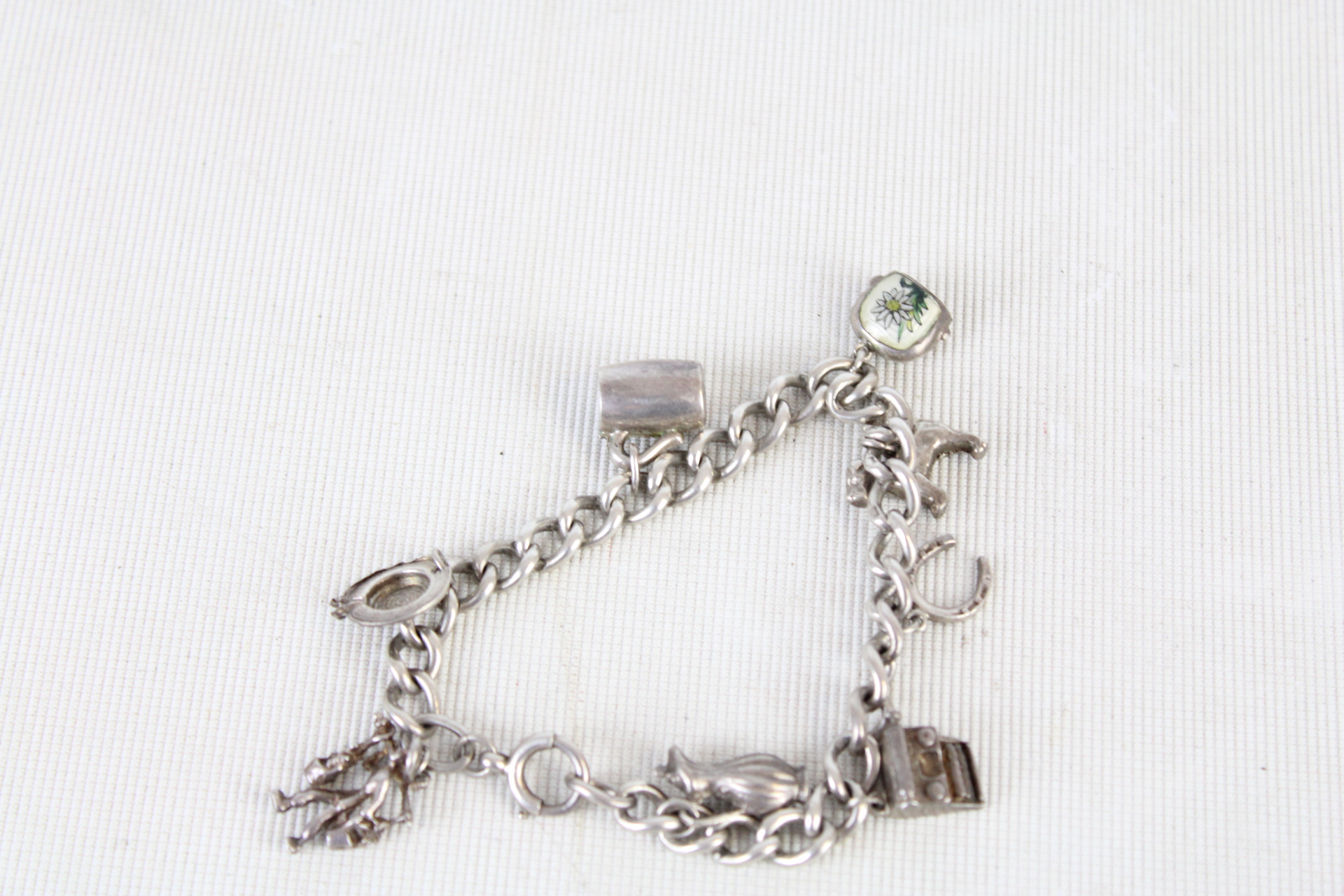 Silver charm bracelet - 8 charms 32.9g