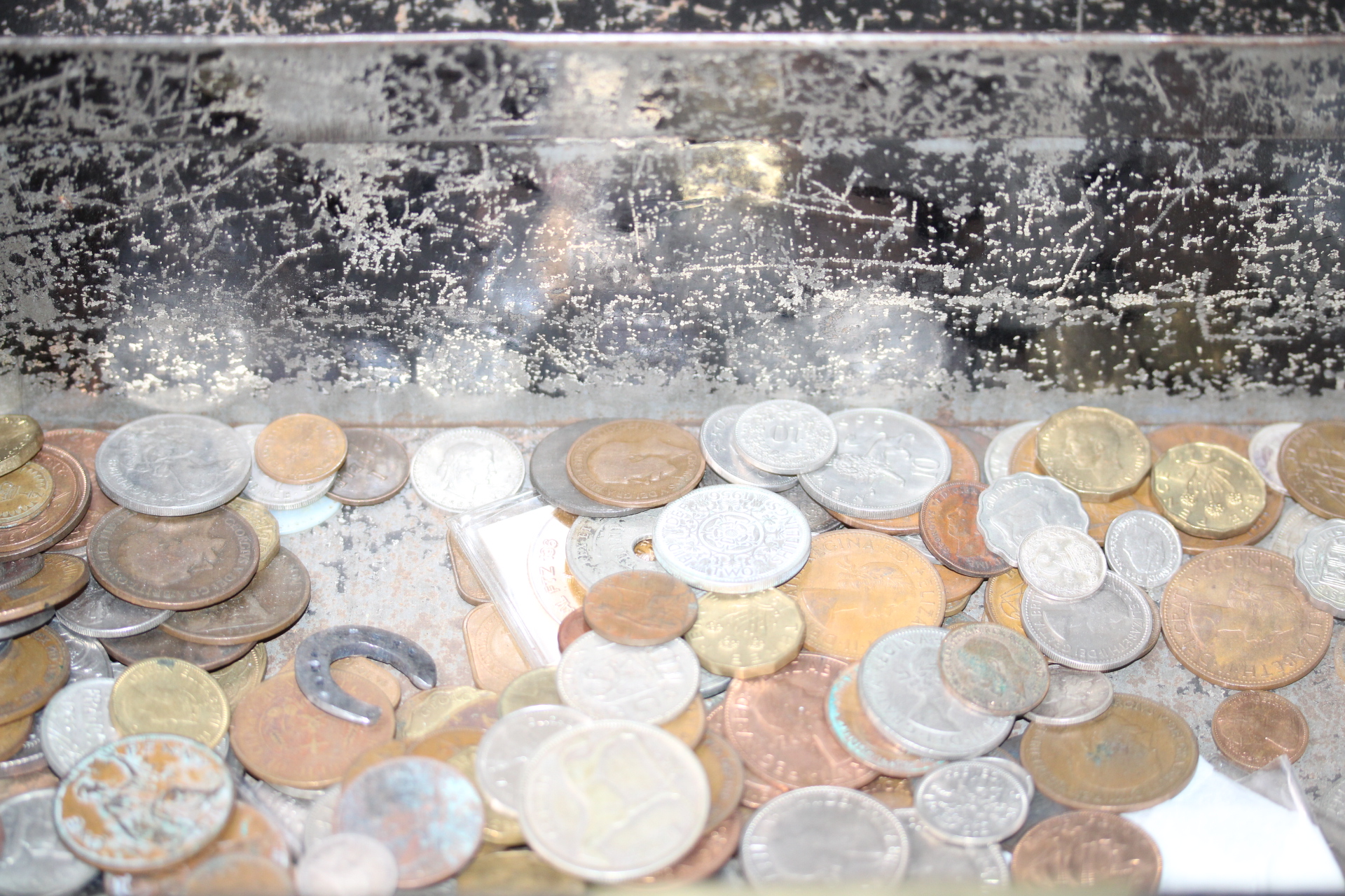 Large unsorted coin collection in an early safe box