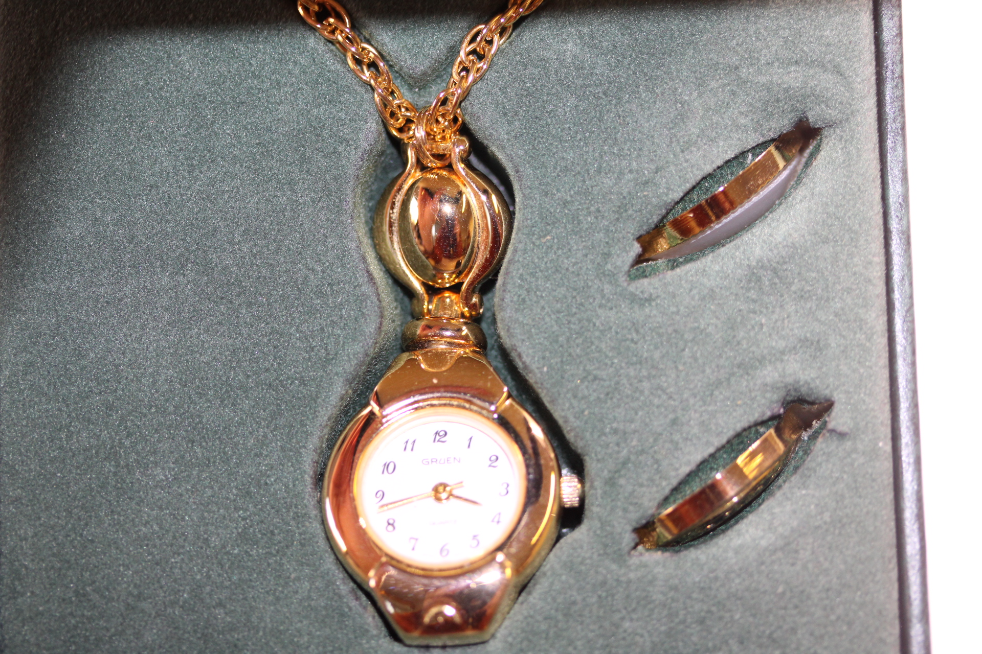 Ladies Gruen Pendant Quartz Watch on Gold Coloured Chain in Box with Optional Case Backs which can be Screwed in Place and Papers and Spare Batteries.