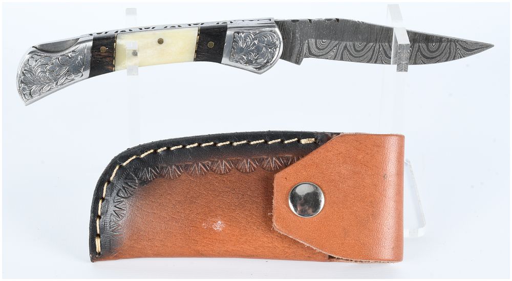 Lot 410: A Decorative Damascus Steel Folding Knife with Fitted Leather Sheath