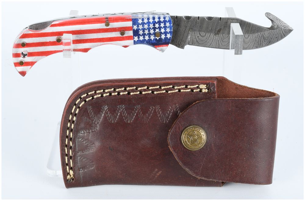 Lot 1559: A Modern Custom Handmade Damascus Steel Folding Knife with American Flag Handle and Leather Sheath