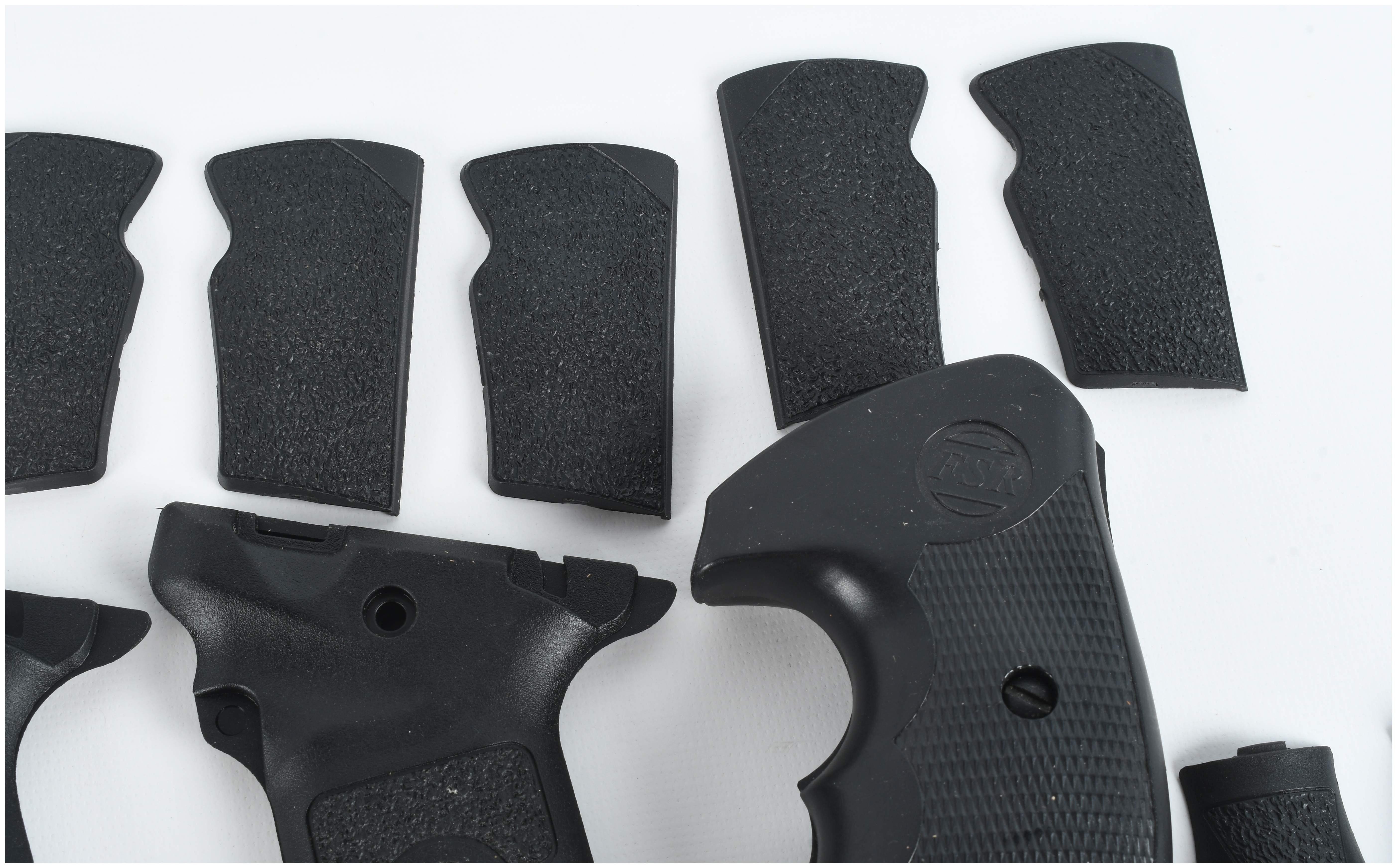 A Collection of 4 Smith & Wesson and FSR Handgun Grips and Backstrap Components
