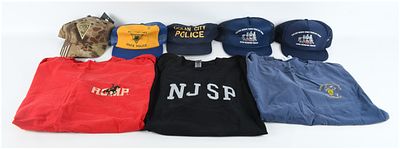 A Lot of 8 Law Enforcement Themed T-Shirts and Baseball Hats. A collection of 8 law 