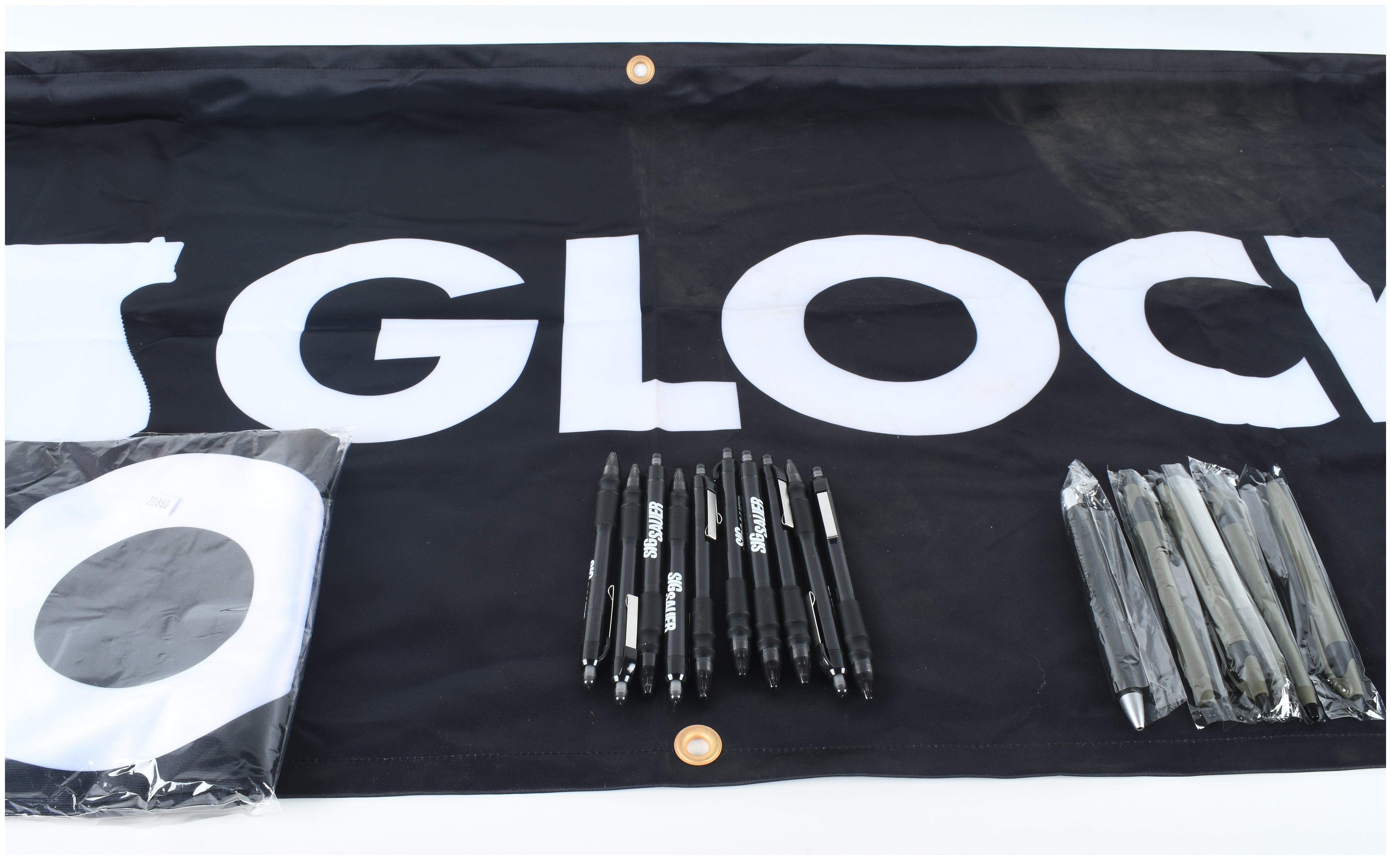 A Collection of Glock and Sig Sauer Promotional Merchandise Including Banners and Pens