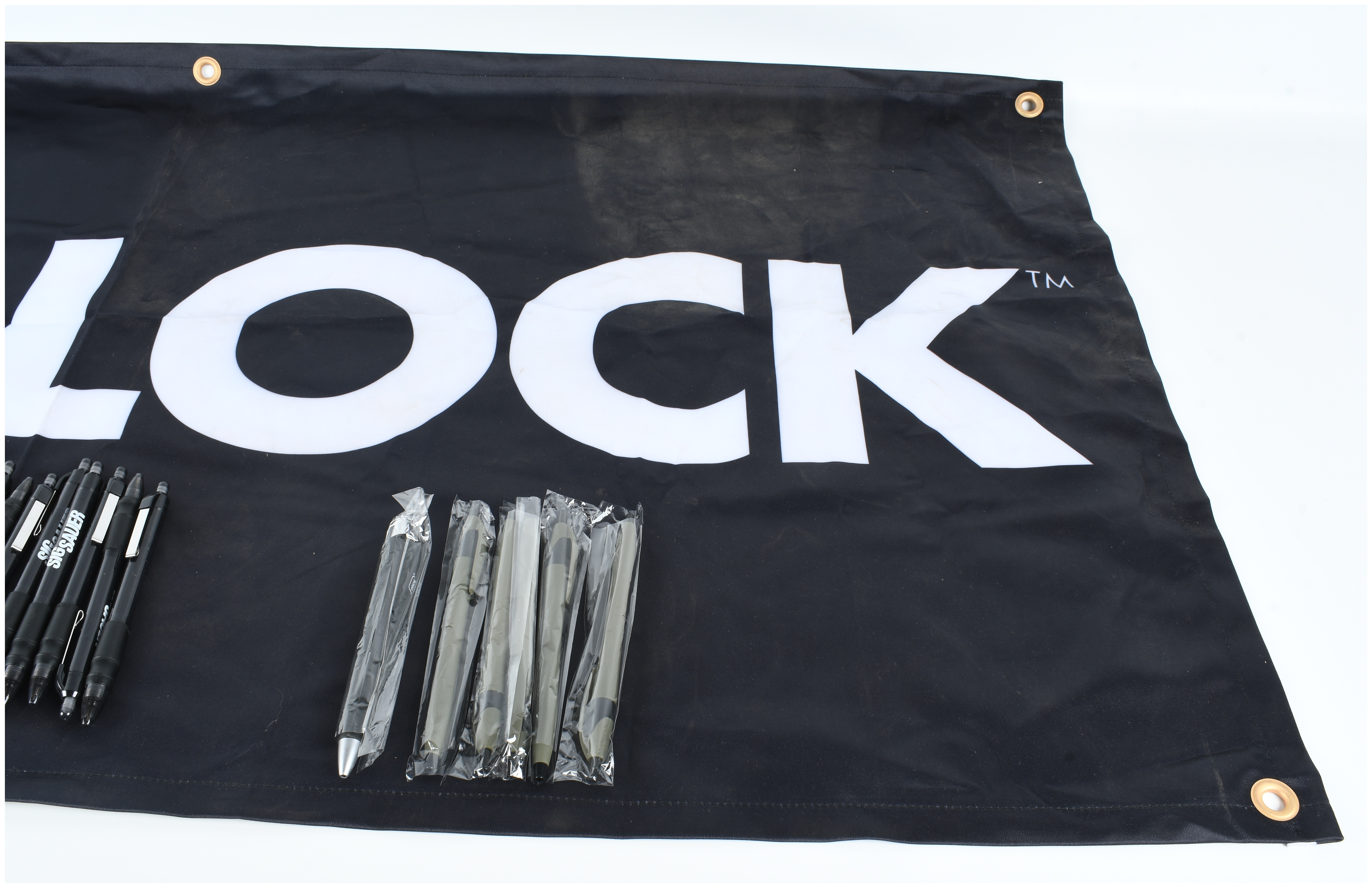 A Collection of Glock and Sig Sauer Promotional Merchandise Including Banners and Pens