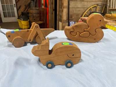 Two Natural Wood Pull-Toys: Whale and Grasshopper. Two natural wood-colored pull-toys, including 