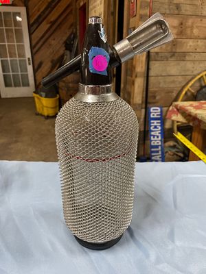 Vintage Glass Seltzer Bottle with Metal Mesh. A single silver metal mesh and black seltzer 