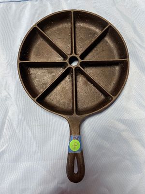 Cast Iron Cornbread Pan with 8 Wedge Compartments. A dark brown/black cast iron cornbread pan 