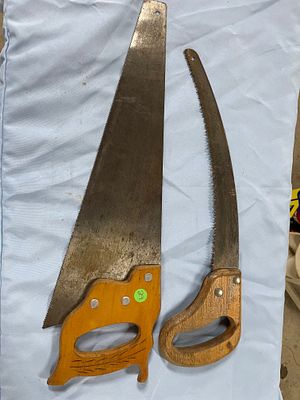 Two Vintage Hand Saws. Two saws, one larger hand saw with a dark metal blade and an orange-brown 