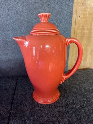 Fiesta Persimmon Ceramic Pitcher by Homer Laughlin. A reddish-orange ceramic pitcher featuring a 