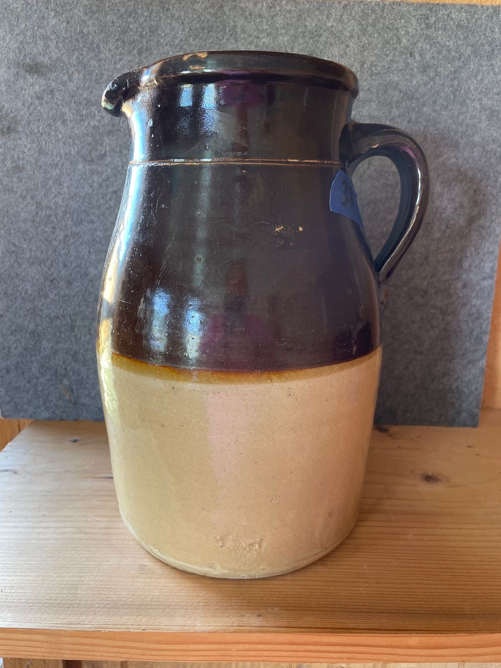 Two-Tone Brown and Tan Stoneware Pottery Pitcher. A two-tone stoneware pitcher featuring a dark 