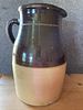 Two-Tone Brown and Tan Stoneware Pottery Pitcher. A two-tone stoneware pitcher featuring a dark Image - 2