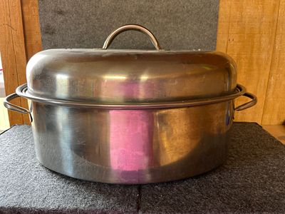 Stainless Steel Oval Roasting Pan with Lid. A stainless steel oval roasting pan featuring a 