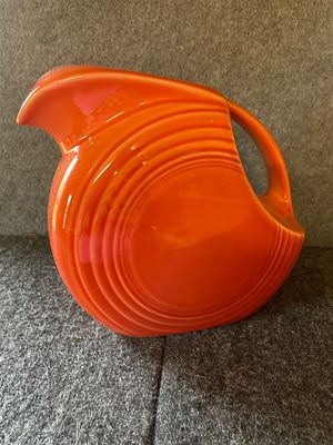 Fiesta Orange Ceramic Juice Pitcher. An orange ceramic juice pitcher featuring concentric ring 