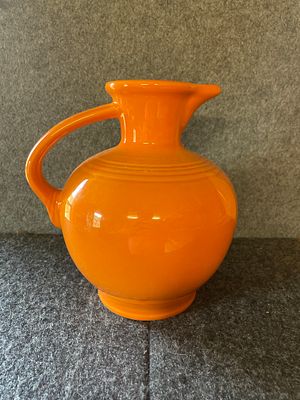 Homer Laughlin Fiesta Orange Ceramic Carafe Pitcher. An orange ceramic carafe featuring a round 