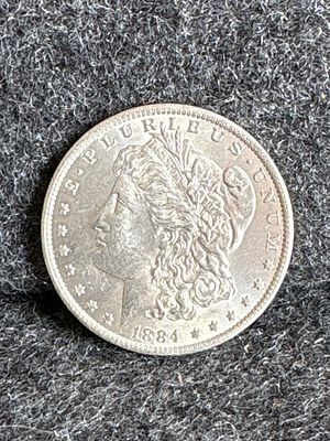 1884-O Morgan Silver Dollar. An 1884-O Morgan silver dollar coin featuring Liberty on the 