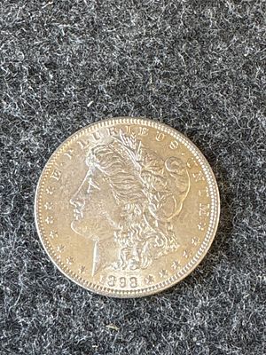 1898 Morgan Silver Dollar Coin. A silver-colored 1898 Morgan dollar coin featuring Liberty on 