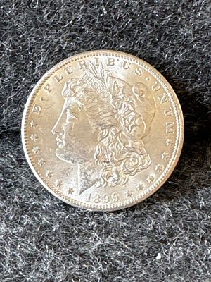 1899 Morgan Silver Dollar Coin. A silver 1899 Morgan silver dollar coin featuring Liberty on the 