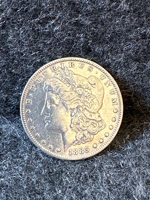 1885-O Morgan Silver Dollar Coin. A silver-colored 1885-O Morgan silver dollar coin featuring 