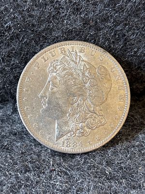 1884-O Morgan Silver Dollar Coin. A silver 1884 Morgan dollar coin featuring the New Orleans O 