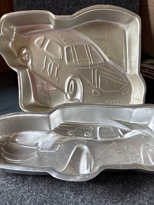 A Collection of Wilton Aluminum Race Car Cake Pans. A collection of silver-colored aluminum cake 