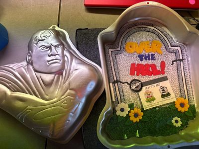 Two Wilton Aluminum Novelty Cake Pans Superman and Tombstone. Two silver-colored aluminum cake 