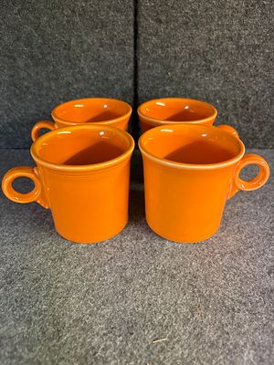 Several Fiesta Tangerine Orange Classic Ring Handle Mugs. Several tangerine orange ceramic mugs 